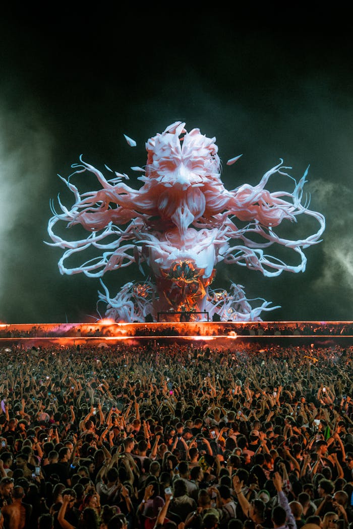 Crowd enjoys a night concert with dazzling digital visuals on stage.